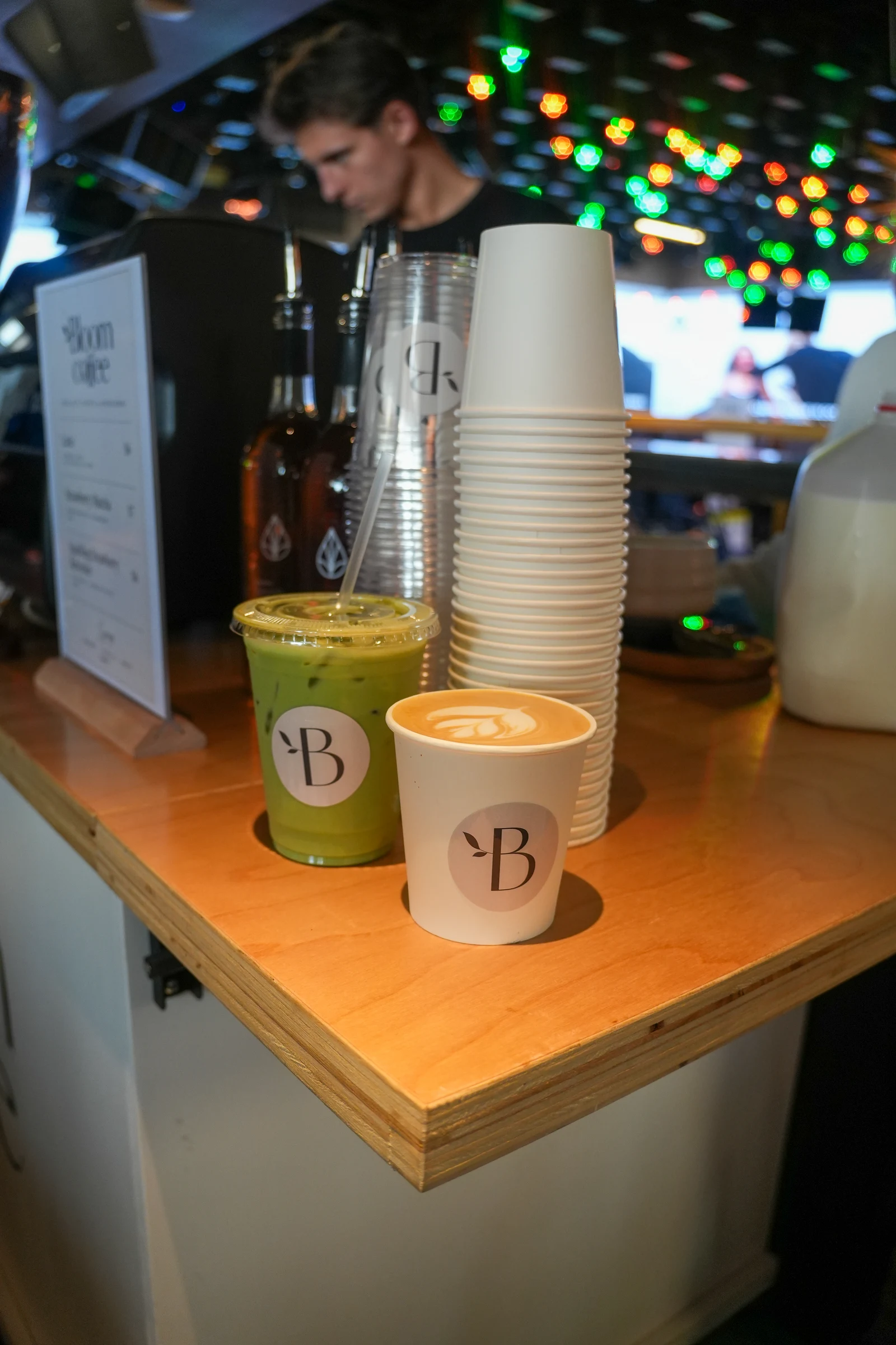 Bloom latte and iced matcha on the cart, with a barista preparing drinks behind them